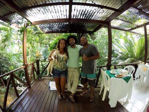 un grupo de tres personas de pie en una terraza de madera en Pousada Luzena, en Morro de São Paulo