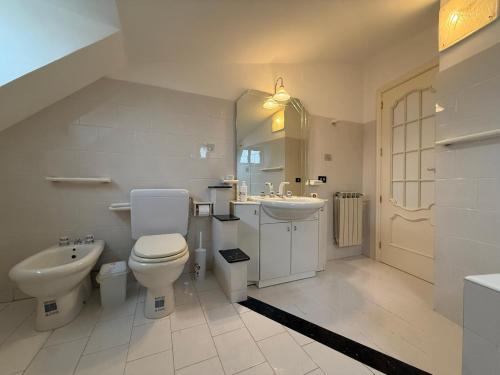 a white bathroom with a toilet and a sink at Terra D'Amuri in Barrafranca
