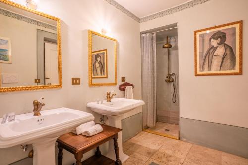 a white bathroom with two sinks and a shower at Palazzo Tombesi Trecci in Montepulciano