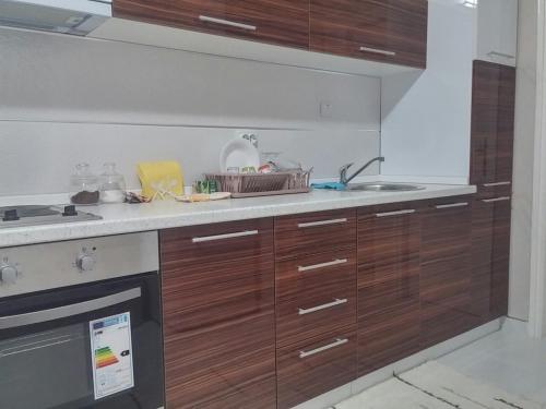 a kitchen with wooden cabinets and a sink at Apartman Sweet dreams 1 in Niš