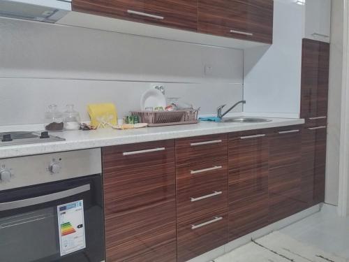 a kitchen with wooden cabinets and a sink at Apartment Stan na dan in Niš