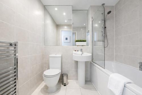 a bathroom with a toilet and a sink and a tub at Roomspace Serviced Apartments - Abbot's Yard in Guildford