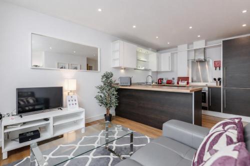 a living room with a couch and a kitchen at Roomspace Serviced Apartments - Abbot's Yard in Guildford