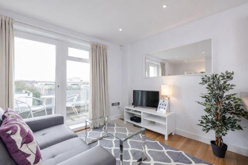 a living room with a couch and a tv at Roomspace Serviced Apartments - Abbot's Yard in Guildford
