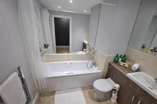 a bathroom with a tub and a toilet and a sink at 2 Bed Flat - Contractor - Central MK - Parking - Sleeps5 in Milton Keynes
