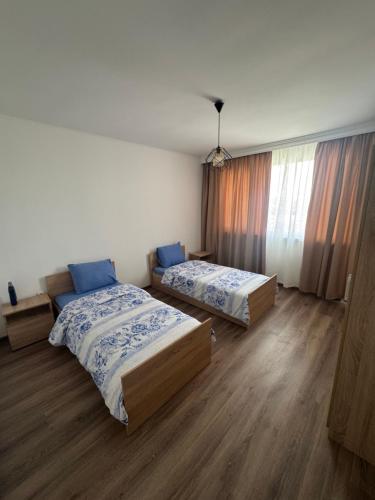 two beds in a room with wooden floors at Luxury House LUXIMMO in Lyetnitsa