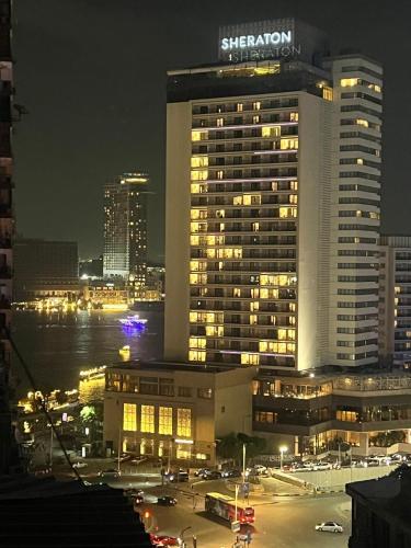 a large building with lights in a city at night at Deluxe Apartment Partial Nile View in Cairo