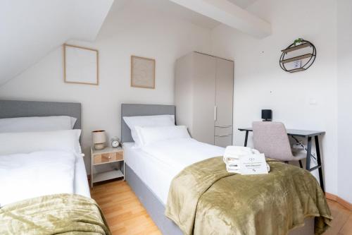 a bedroom with two beds and a desk with a chair at Large Maisonette I 90 m2 I For Groups & Families I 9 Guests I 3 Rooms in Kapfenberg