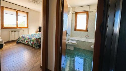 a bathroom with a tub and a toilet and a bed at Moderno Attico a due passi dal Mare in Senigallia