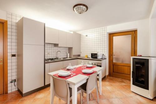 a kitchen with a white table and white appliances at Dolomiti Cadore Home in San Pietro di Cadore