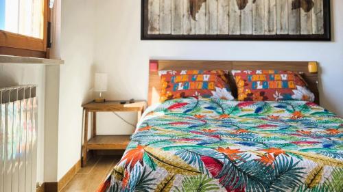 a bedroom with a bed with a colorful comforter at Moderno Attico a due passi dal Mare in Senigallia