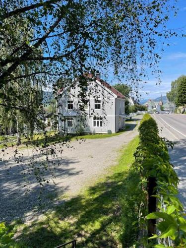 an old white house on the side of a road at Sentrumsnær leilighet - K1 in Lillehammer