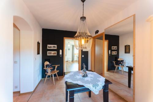 a dining room with a table and a chandelier at Ferienwohnung Lois ***** in Eggstätt