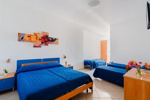 a bedroom with two beds with blue sheets at B&B Gioiello del Mare in Torre Lapillo