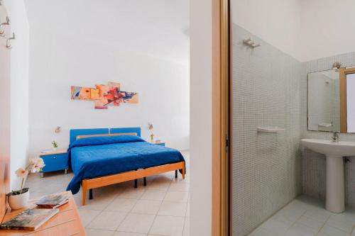 a bedroom with a blue bed and a bathroom at B&B Gioiello del Mare in Torre Lapillo