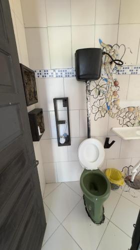 a bathroom with a green toilet in a room at Quartos Beira Mar ARROIO TEIXEIRA in Capão da Canoa