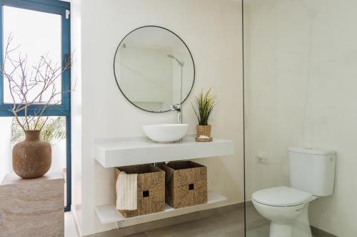a bathroom with a white sink and a mirror at Villa Zendaya in Yaiza