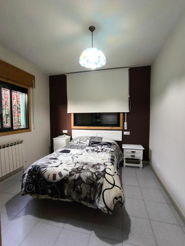 a bedroom with a bed and a large window at Casa Mercedes in Quiroga
