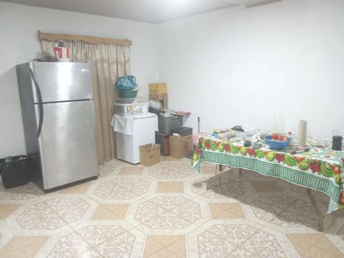 eine Küche mit einem Edelstahlkühlschrank und einem Tisch in der Unterkunft Finca Apolonia in Caldera