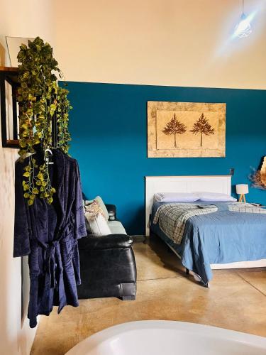 a bedroom with a bed and a blue wall at Chalé Cabana c/ Hidro, Vista e Superhost -Jundiaí in Jundiaí