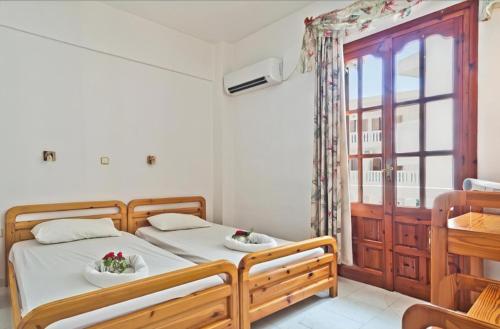 a bedroom with two beds and a window at Sea Stone Apartments in Karpathos