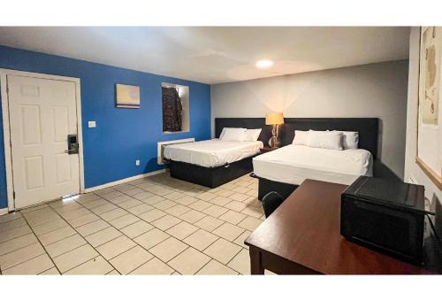 a hotel room with two beds and blue walls at Studio 6 Suites Albany, GA in Albany