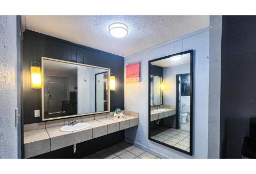 a bathroom with two sinks and two mirrors at Studio 6 Suites Albany, GA in Albany