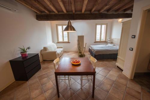 a living room with a table and a bedroom at B&B Le Grazie in Parma