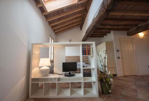 a room with a computer on a white shelf at B&B Le Grazie in Parma