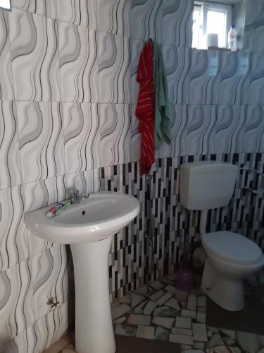 a bathroom with a sink and a toilet at Happy Corner Beach Garden in How Ba