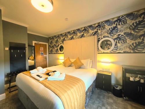 a hotel room with a bed with two towels on it at Yardley Manor Hotel in Torquay