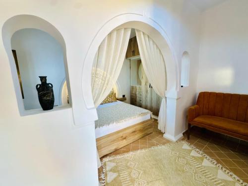 a bedroom with a bed and a couch at Dar Sofien Erriadh Djerba in Erriadh