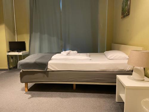 a bedroom with a bed and a desk with a television at Hotel M68 in Berlin