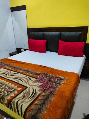 a bedroom with a large bed with red pillows at Hotel Neelkanth in Vrindāvan