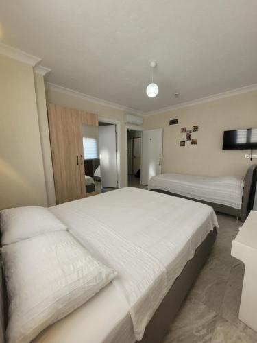 a large bedroom with two beds and a television at Ayvalık Akan Pansiyon in Ayvalık