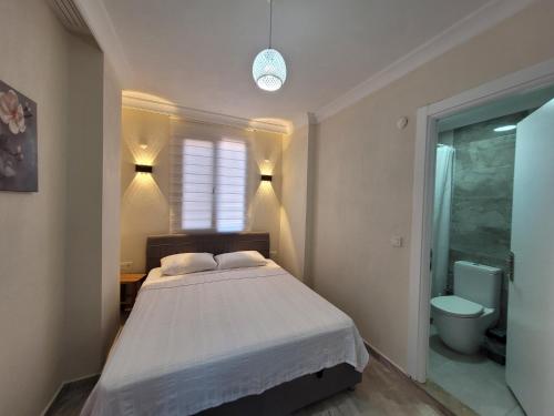 a bedroom with a bed and a bathroom with a toilet at Ayvalık Akan Pansiyon in Ayvalık