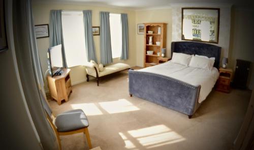 ein Schlafzimmer mit Bett, Stuhl und Fernseher in der Unterkunft O'Gradys Hotel in Redcar