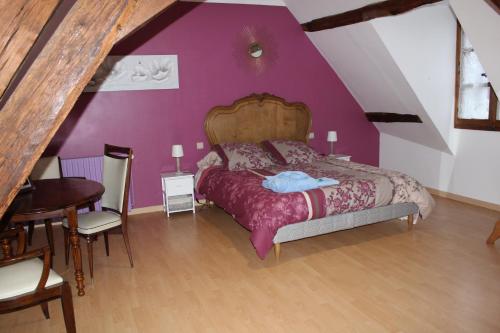 a bedroom with a bed and a purple wall at Domaine de la Touche Mosnay in Mosnay