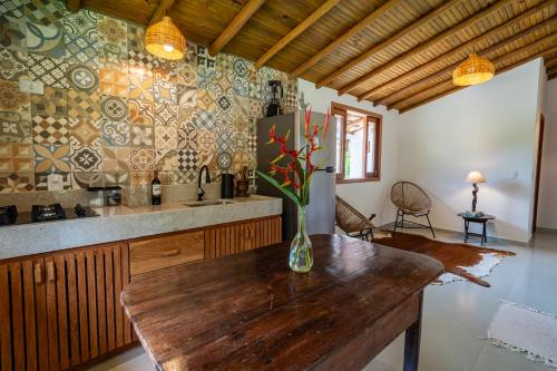 a kitchen with a vase of flowers on a wooden table at Casa Xibas e Loft Trancoso in Trancoso