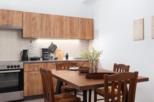 a kitchen with a wooden table and wooden cabinets at Andros Apartments with Free Parking in Steniaí