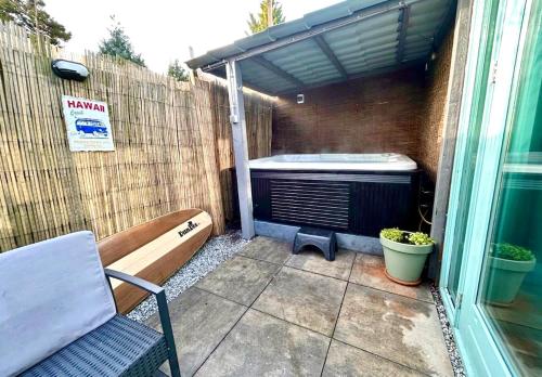 a patio with a bench and an air conditioner at Cozy comfortable house with jacuzzi & private garden near Amsterdam in Vijfhuizen