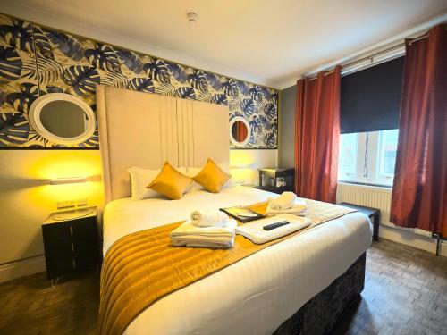 a bedroom with a large bed with towels on it at Yardley Manor Hotel in Torquay