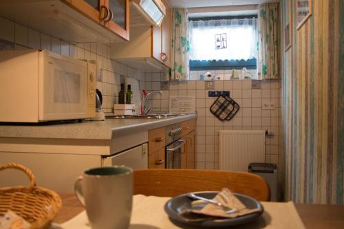 a kitchen with a table with a coffee cup on it at Ferienwohnung Küssner in Kiel