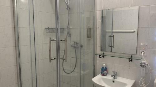 a bathroom with a shower and a sink and a mirror at Hotel M68 in Berlin