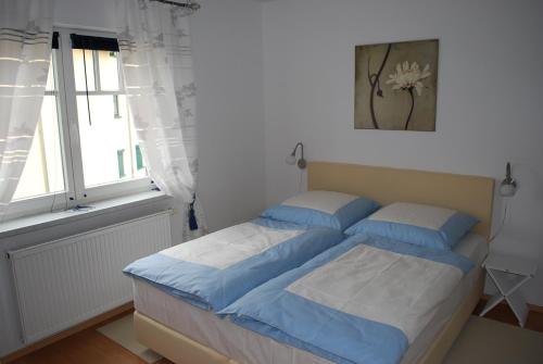 a bedroom with a bed with blue sheets and a window at Seepark in Bansin