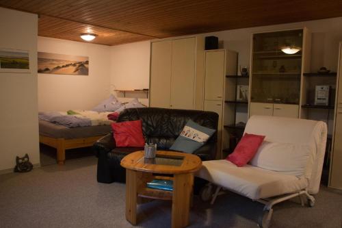 a living room with a couch and a table and a bed at Ferienwohnung Küssner in Kiel