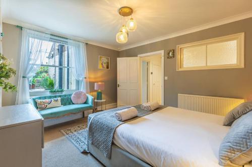 a bedroom with a bed and a couch and a window at Spacious Seafront Apartment, Garden Free Parking in Littlehampton