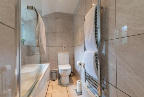 a bathroom with a toilet and a tub and a sink at Spacious Seafront Apartment, Garden Free Parking in Littlehampton