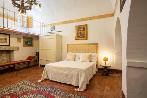 a bedroom with a white bed and a fireplace at Palazzo Danesi in Montepulciano