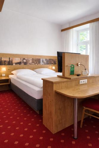 a bedroom with a bed and a desk and a table at Gasthof Klement in Isen